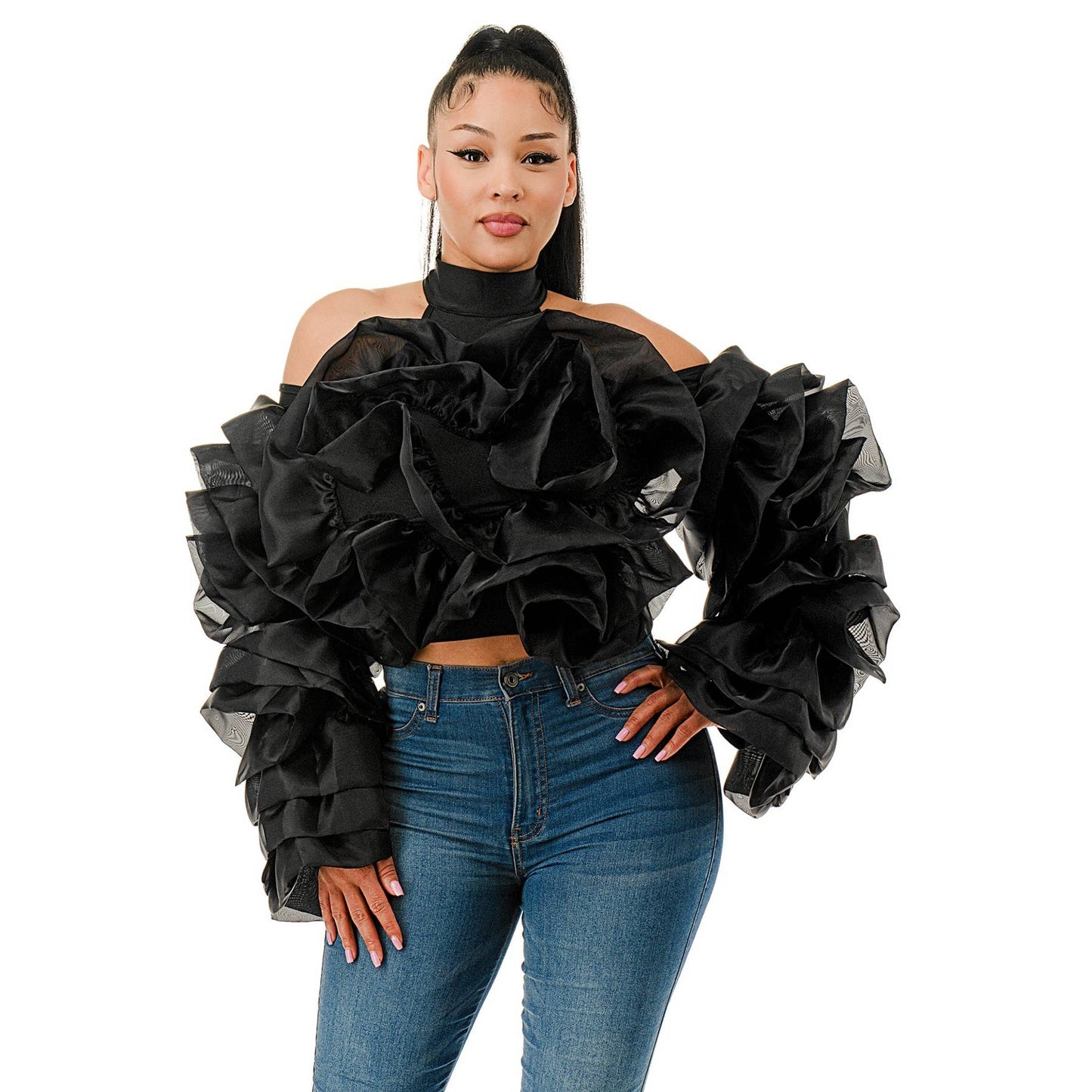 Woman wearing a black ruffled top and blue jeans on a white background