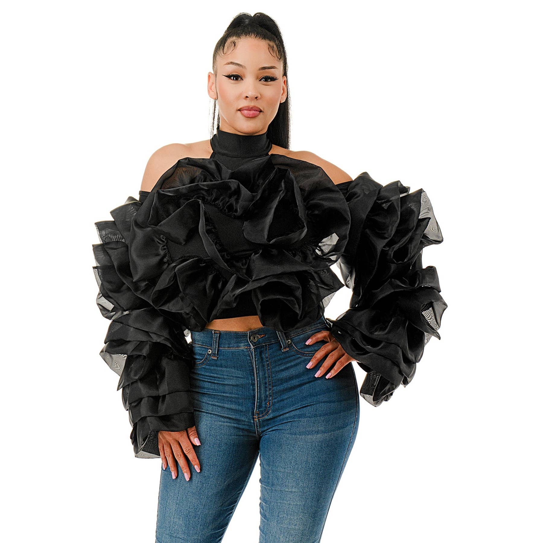 Woman wearing a black ruffled top and blue jeans on a white background