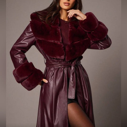 Woman wearing a burgundy fur-trimmed coat with a matching dress against a neutral background