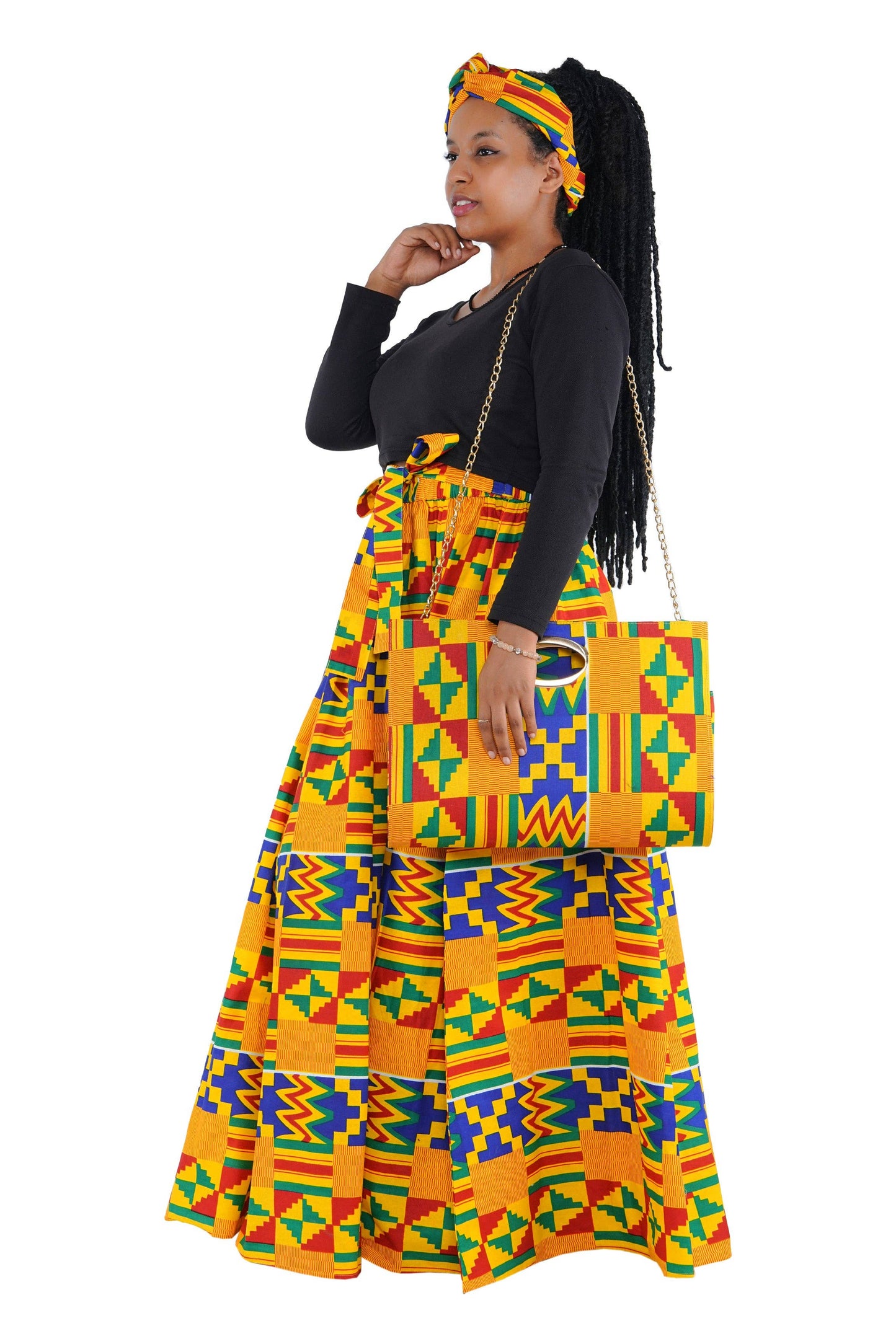 Woman wearing a colorful patterned outfit with a matching handbag on a white background