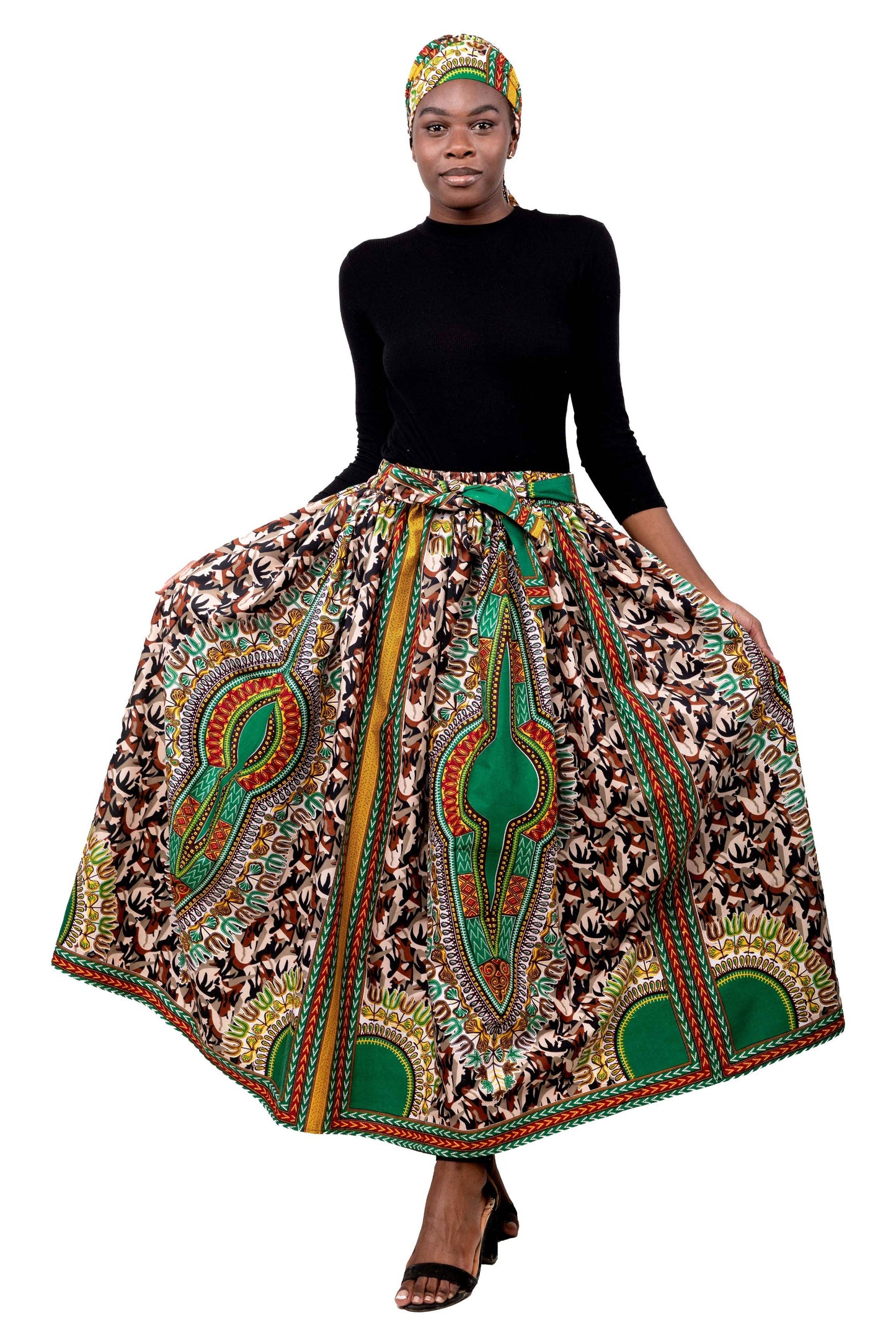 Woman wearing a traditional African print skirt with a black top on a white background