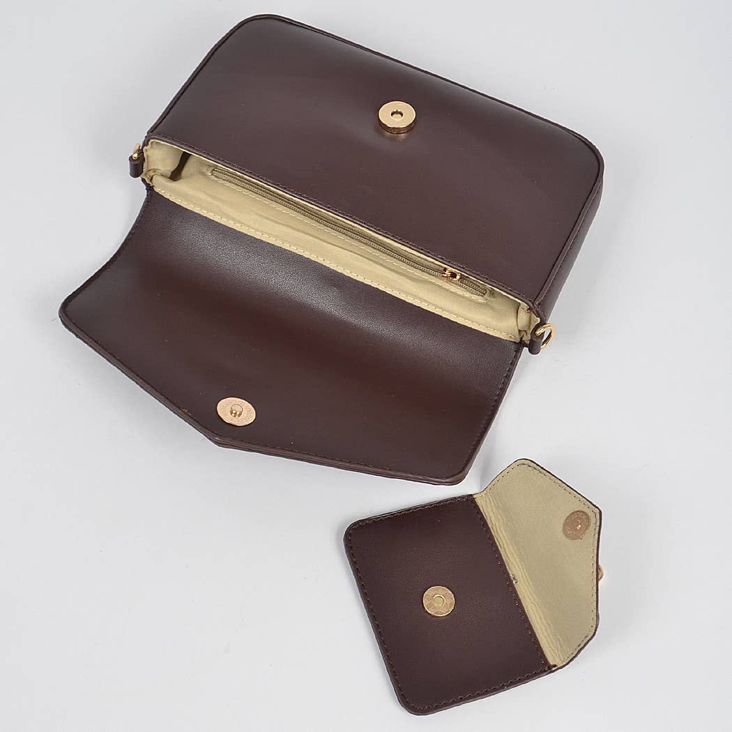 Brown leather clutch with gold accents on a light gray background