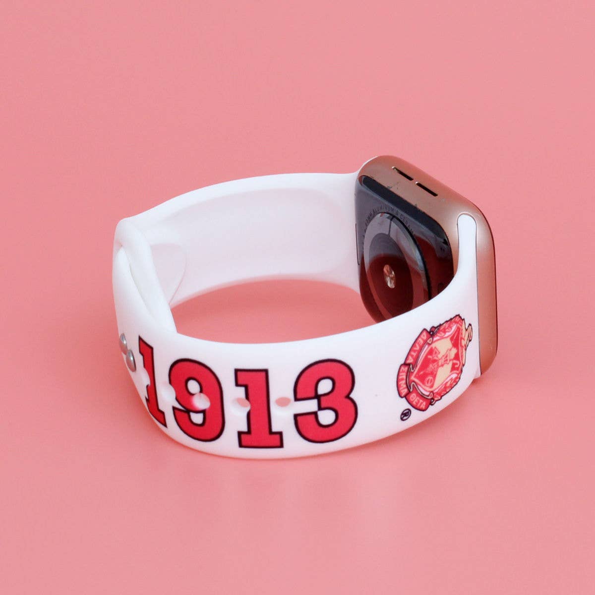 White band with red text and logo on a pink background