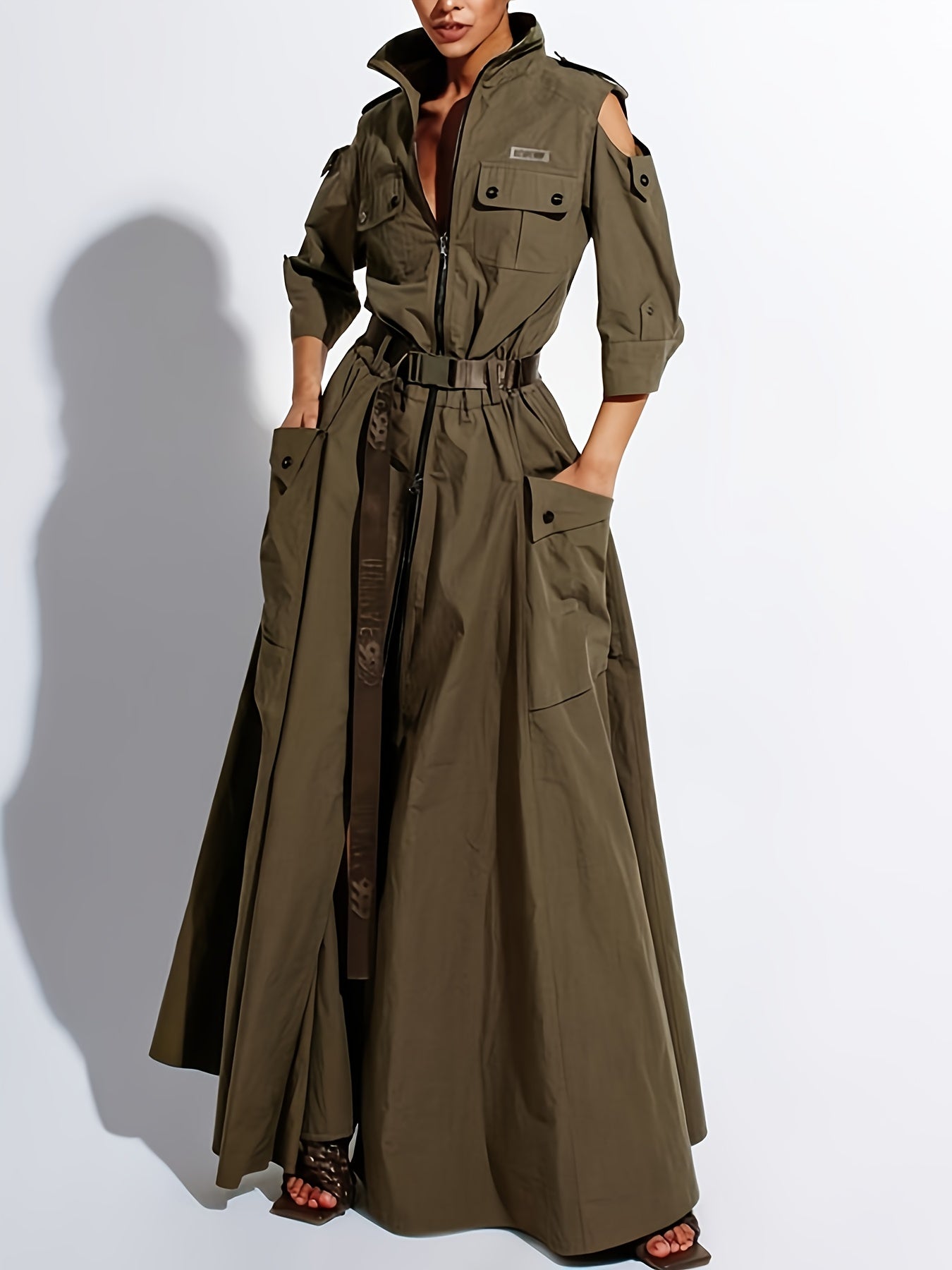 Long olive green trench coat worn by a model on a white background