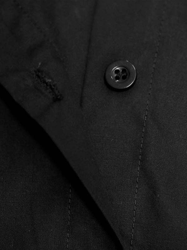 Close-up of a black button on a dark fabric surface
