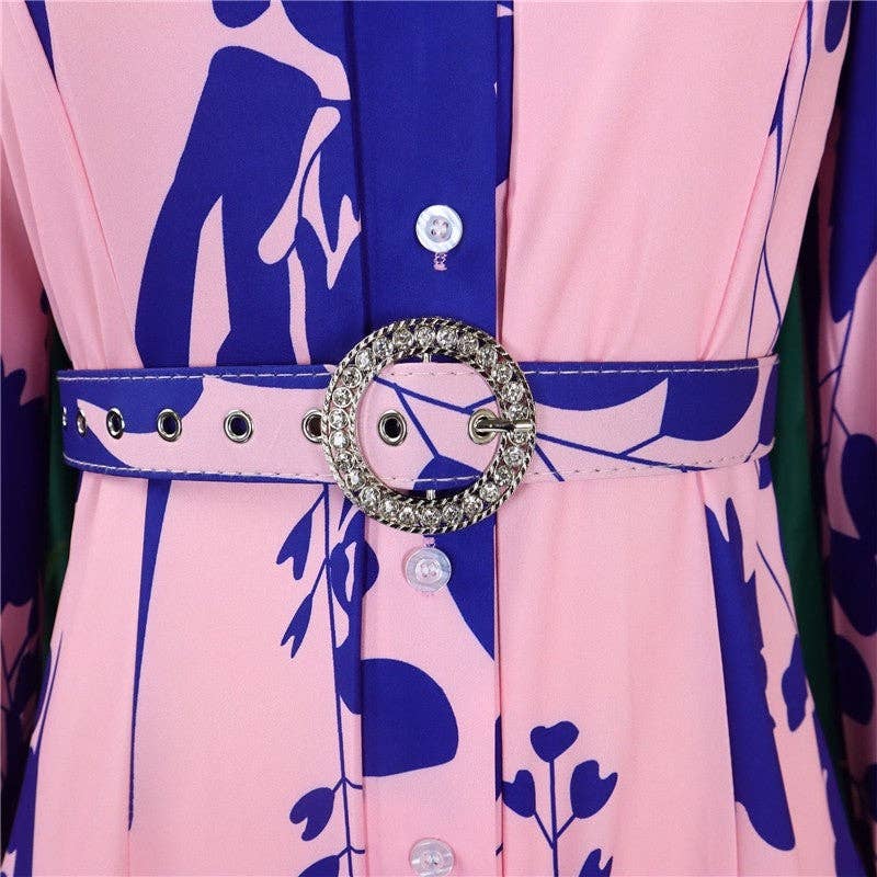 Close-up of a dress with a decorative belt featuring a large round buckle.