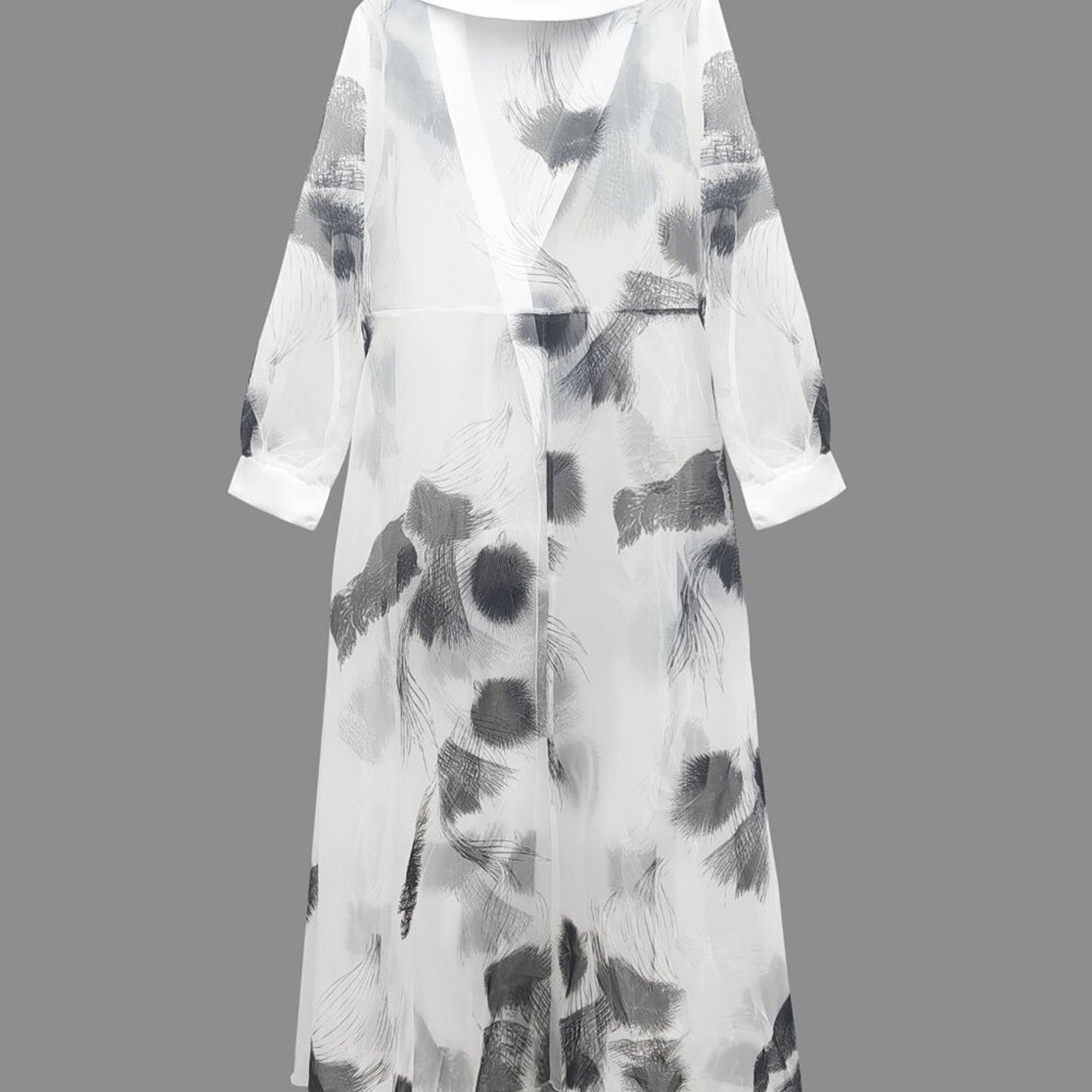 Long, light-colored dress with abstract black patterns on a gray background