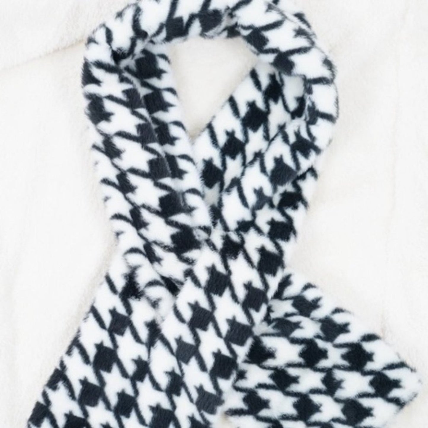 Black and white houndstooth patterned scarf on a white background
