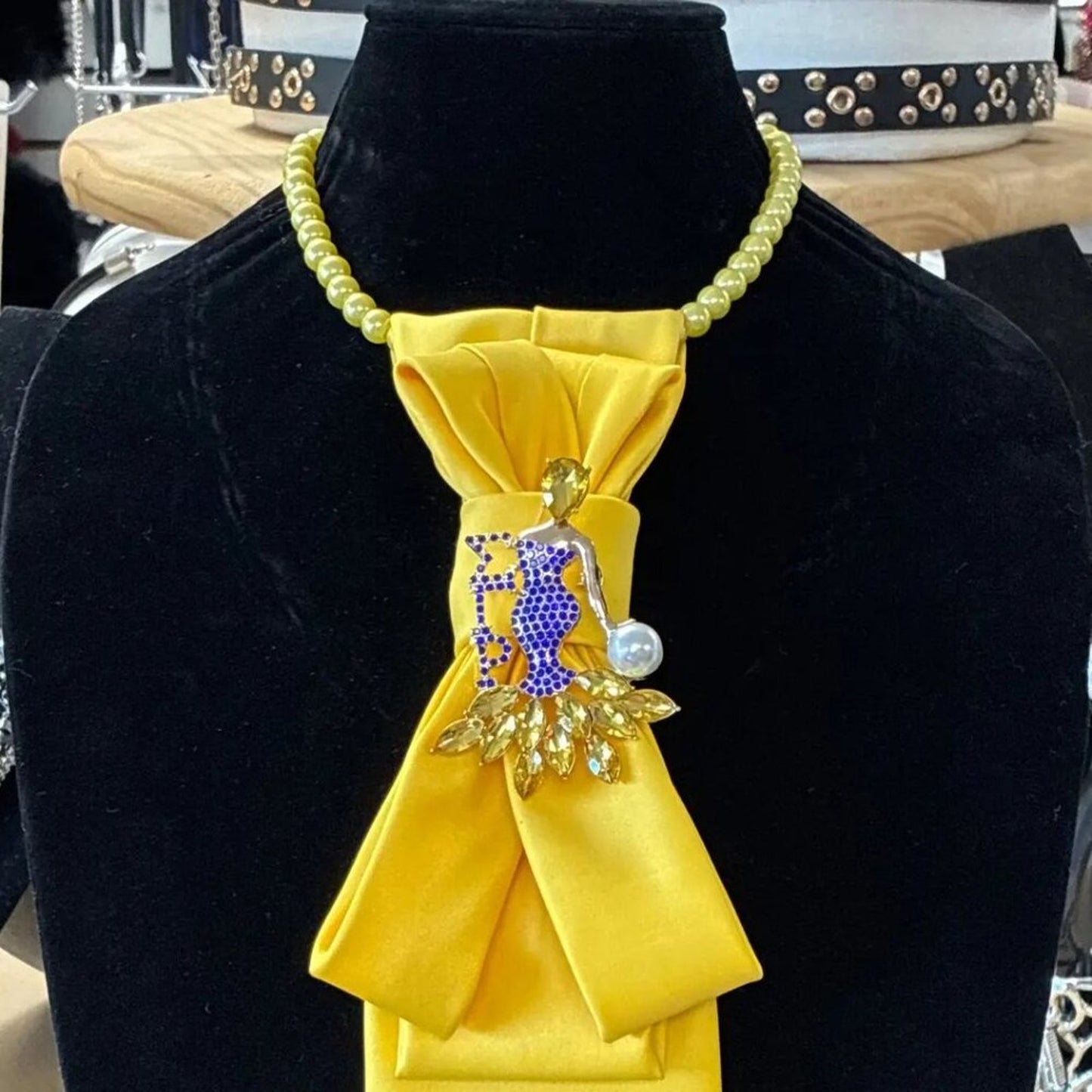 Yellow ribbon with decorative figure and beads on a black background
