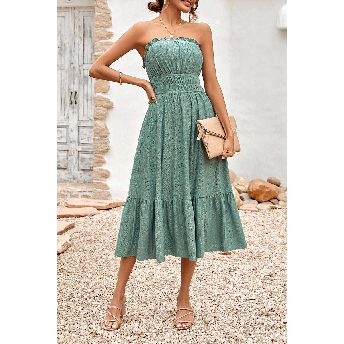Woman wearing a green strapless dress with a neutral background