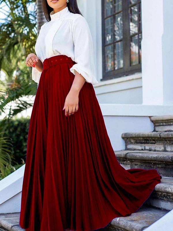 Woman wearing a white blouse and red skirt standing on steps outdoors.