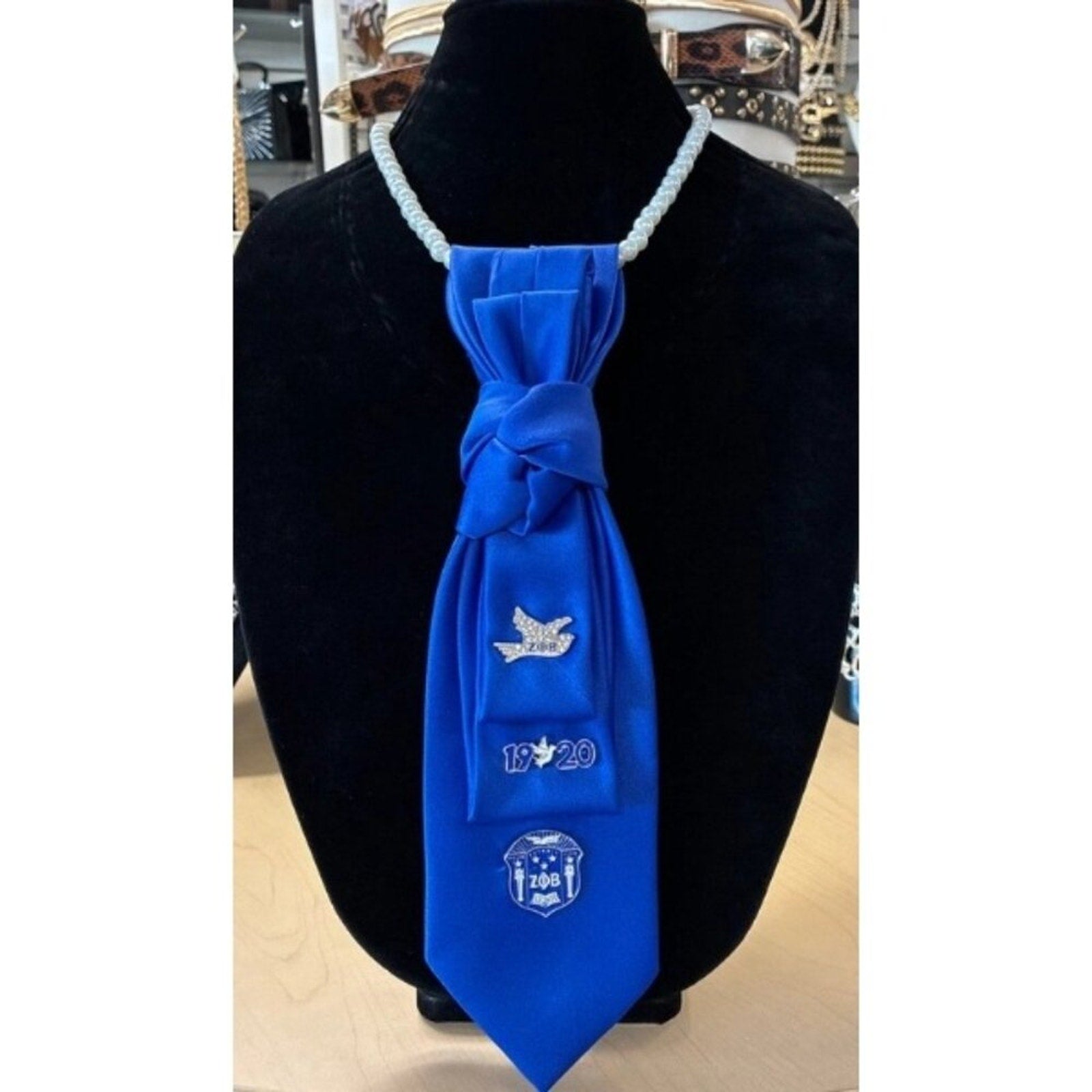 Blue necktie with decorative elements on a black mannequin