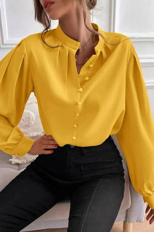 Person wearing a yellow blouse with long sleeves in an indoor setting