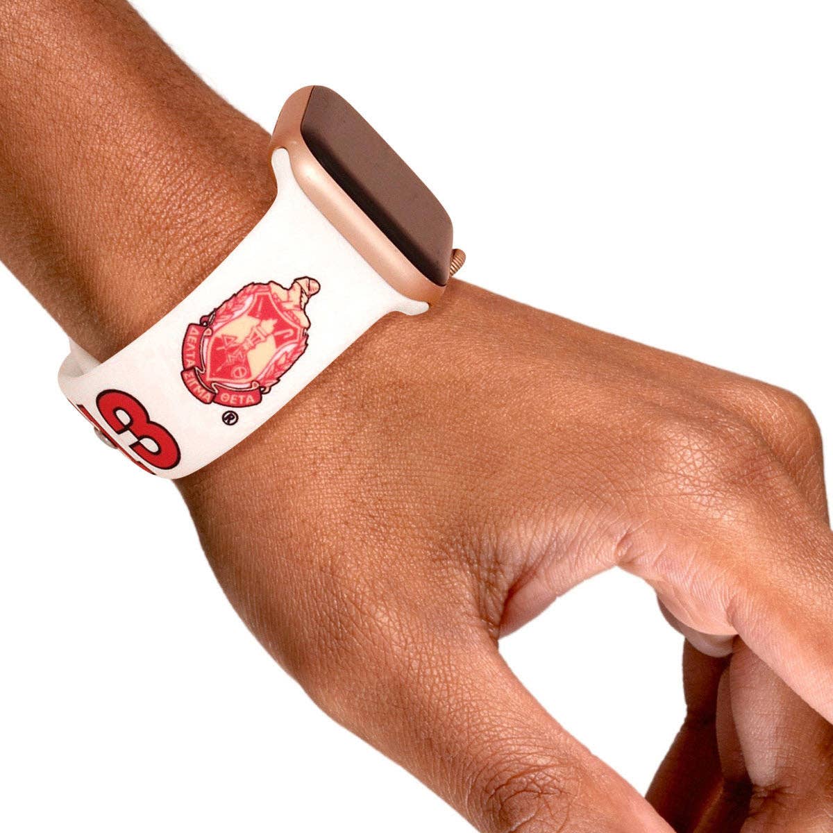 Wrist wearing a white band with a red and yellow design on a white background