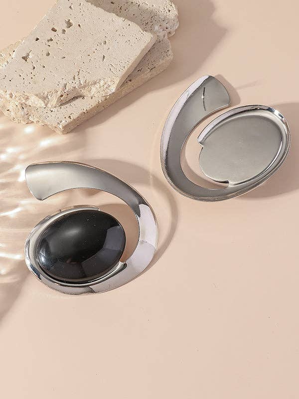 Silver circular objects with a central black sphere on a beige surface