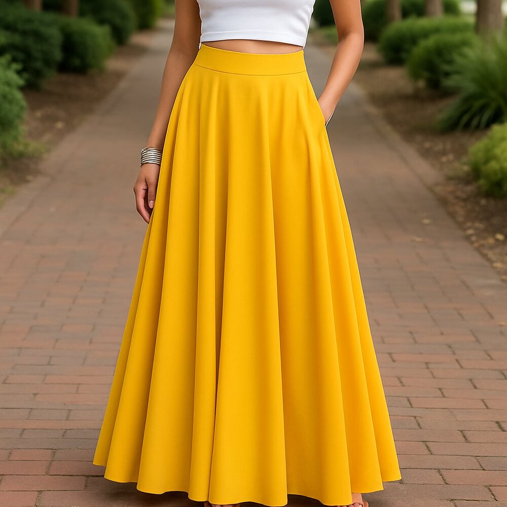 Person wearing a yellow skirt and white top on a brick path with greenery.