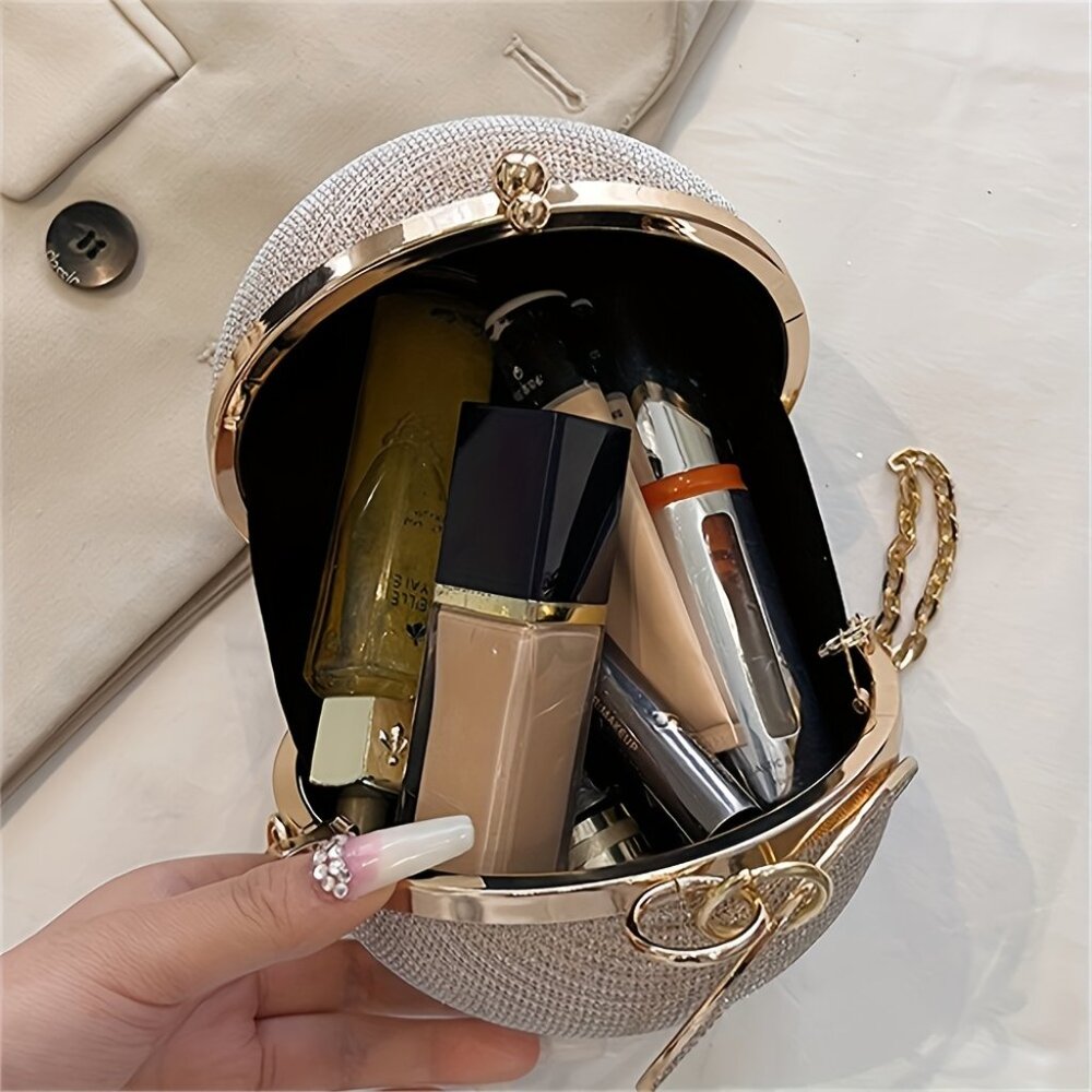 Hand holding a decorative makeup bag with lipsticks and other items.