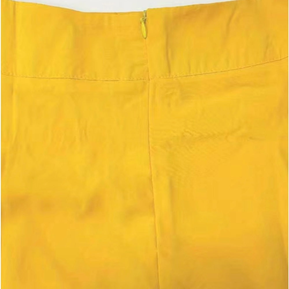 Close-up of a yellow skirt with a zipper detail on a white background