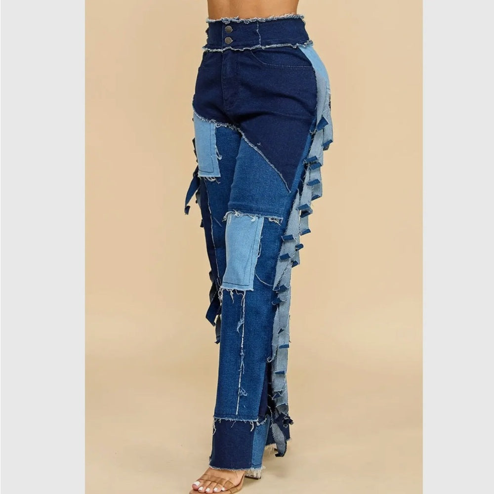 Patchwork denim pants with ruffled details on a beige background