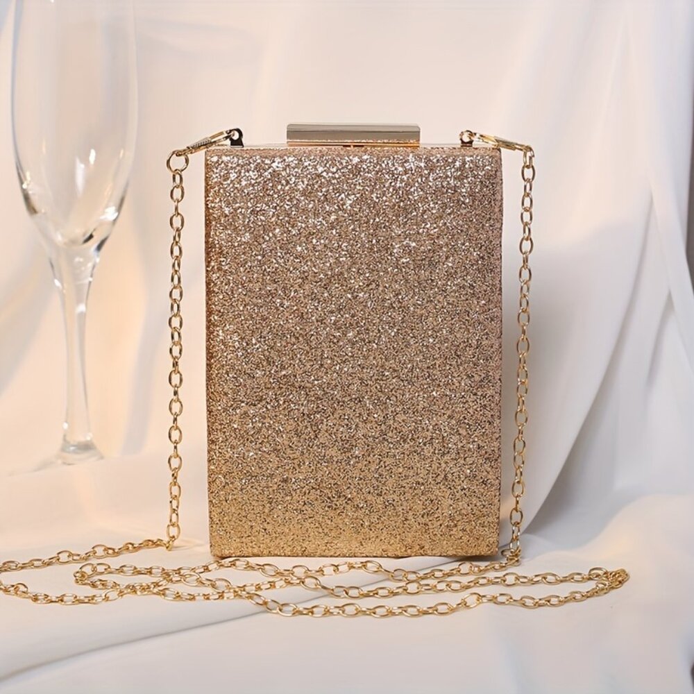 Gold glittery clutch bag with a chain strap on a white background