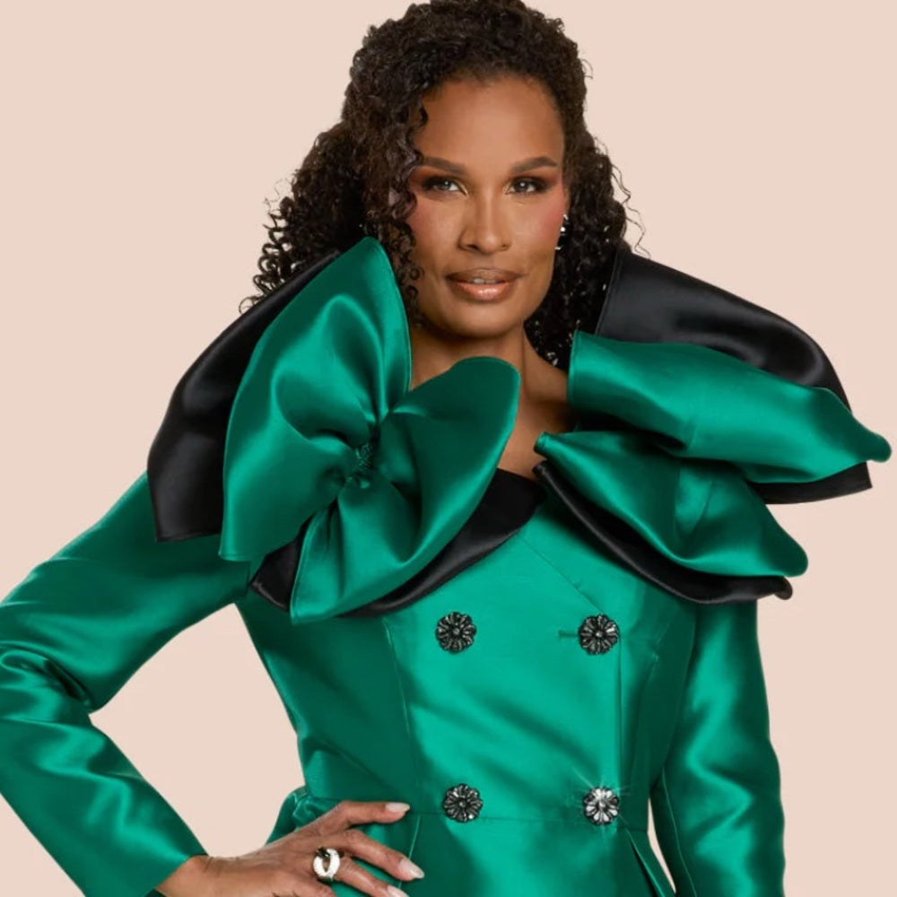 Woman wearing a green and black outfit with large bows on a beige background