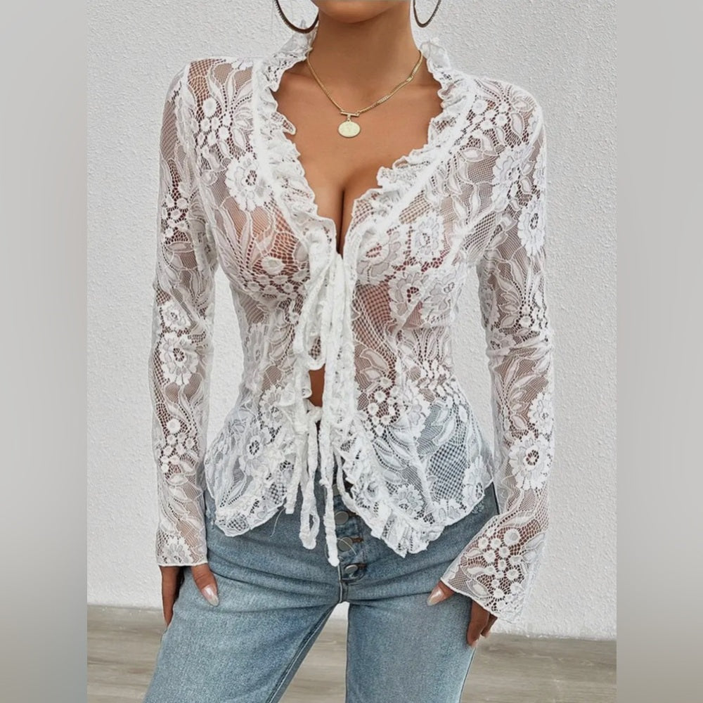 White lace top worn by a person on a plain background