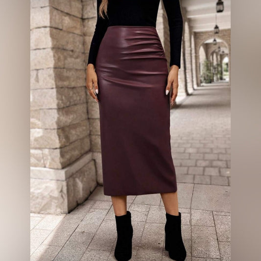 Person wearing a burgundy skirt and black top standing on a stone pathway.