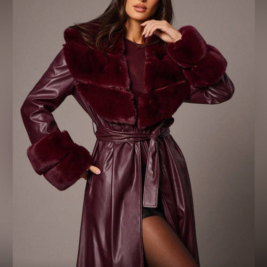 Woman wearing a burgundy fur-trimmed coat with a matching dress against a neutral background
