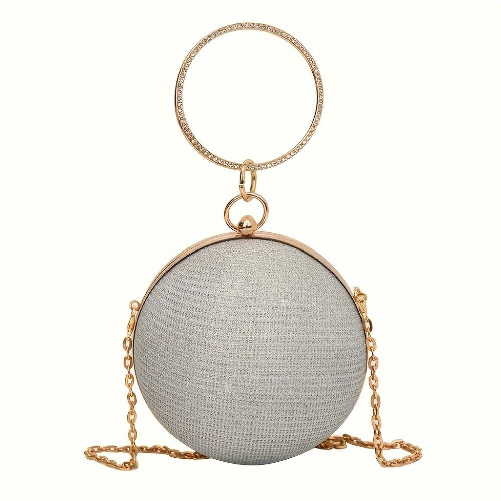 Round metallic clutch with gold chain and handle on a white background