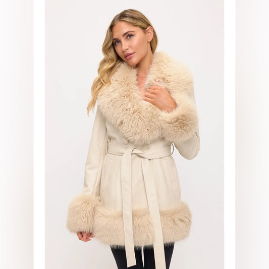 Woman wearing a cream-colored coat with fur trim on a white background