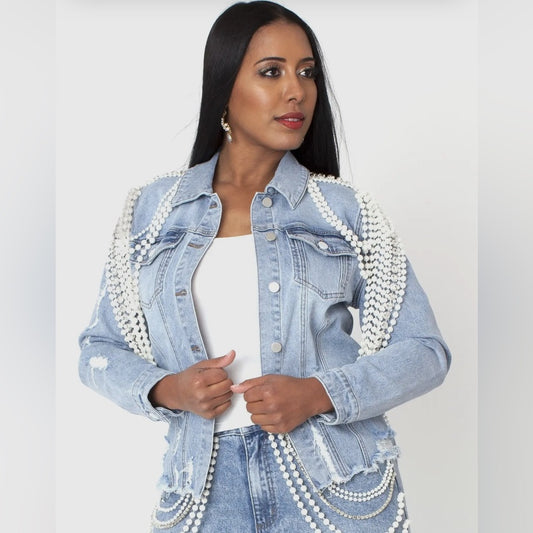 Woman wearing a denim jacket with pearl embellishments on a white background