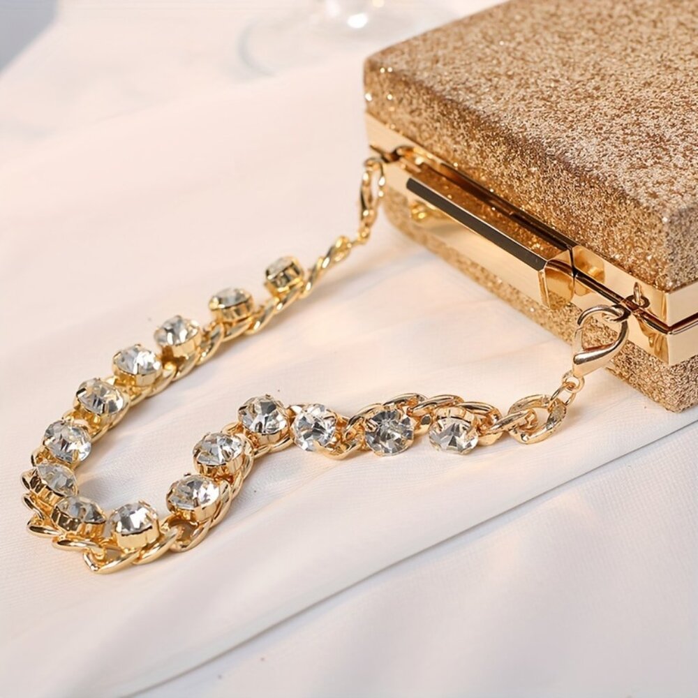 Gold glittery clutch with a chain strap on a light background