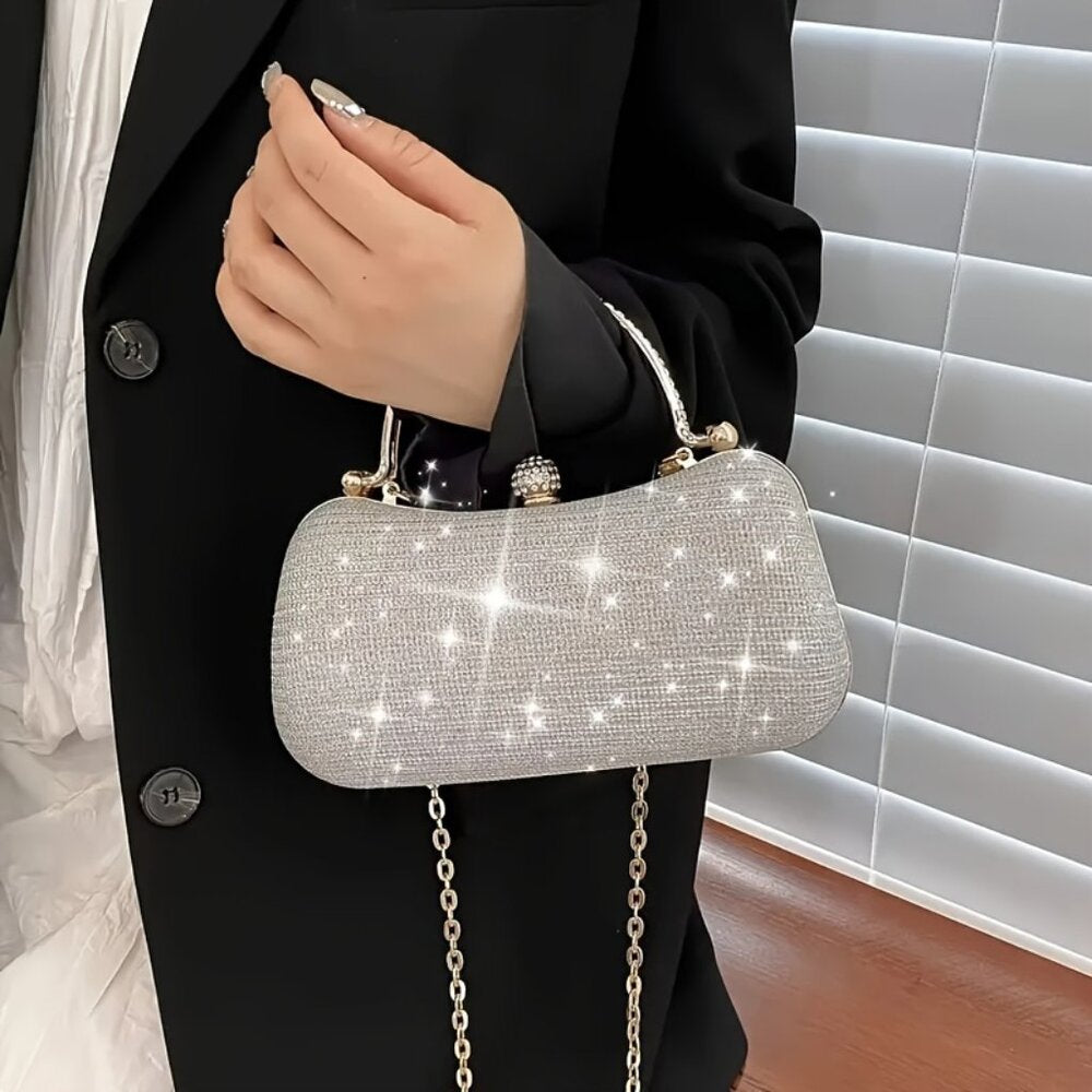 Person holding a sparkling silver handbag with a chain strap against a neutral background