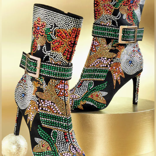 Decorative high-heeled boots with colorful gemstones on a gold background